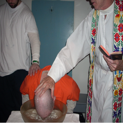 Father Paul baptizing an incarcerated individual in a Philadelphia prison. 